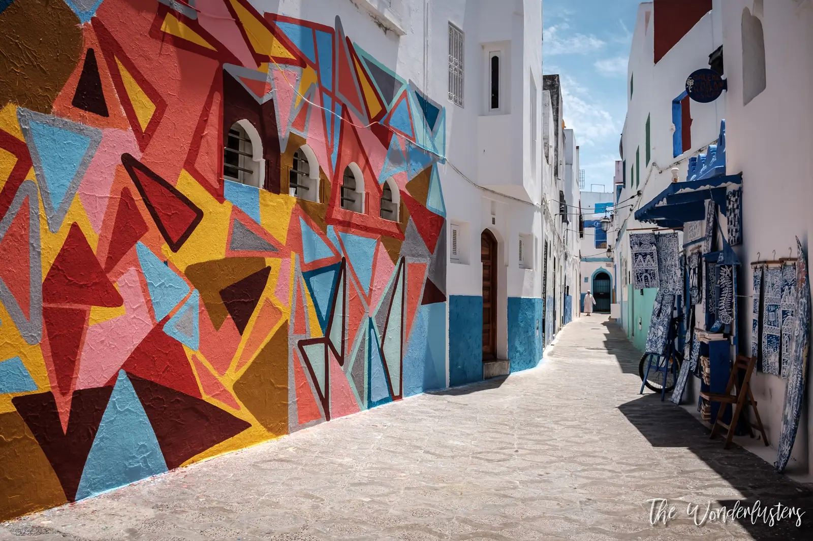 Street art on a whitewashed wall in Asilah